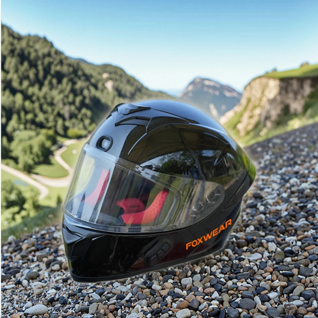 Black Foxwear helmet on pebbles with a mountainous landscape in the background