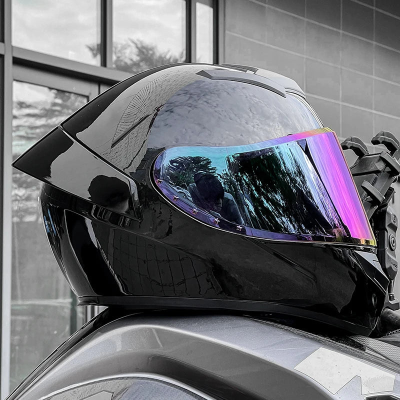 Black motorcycle helmet with a colorful visor on a car roof.