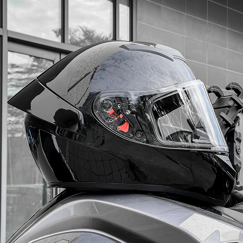 Black motorcycle helmet with clear visor on a motorcycle