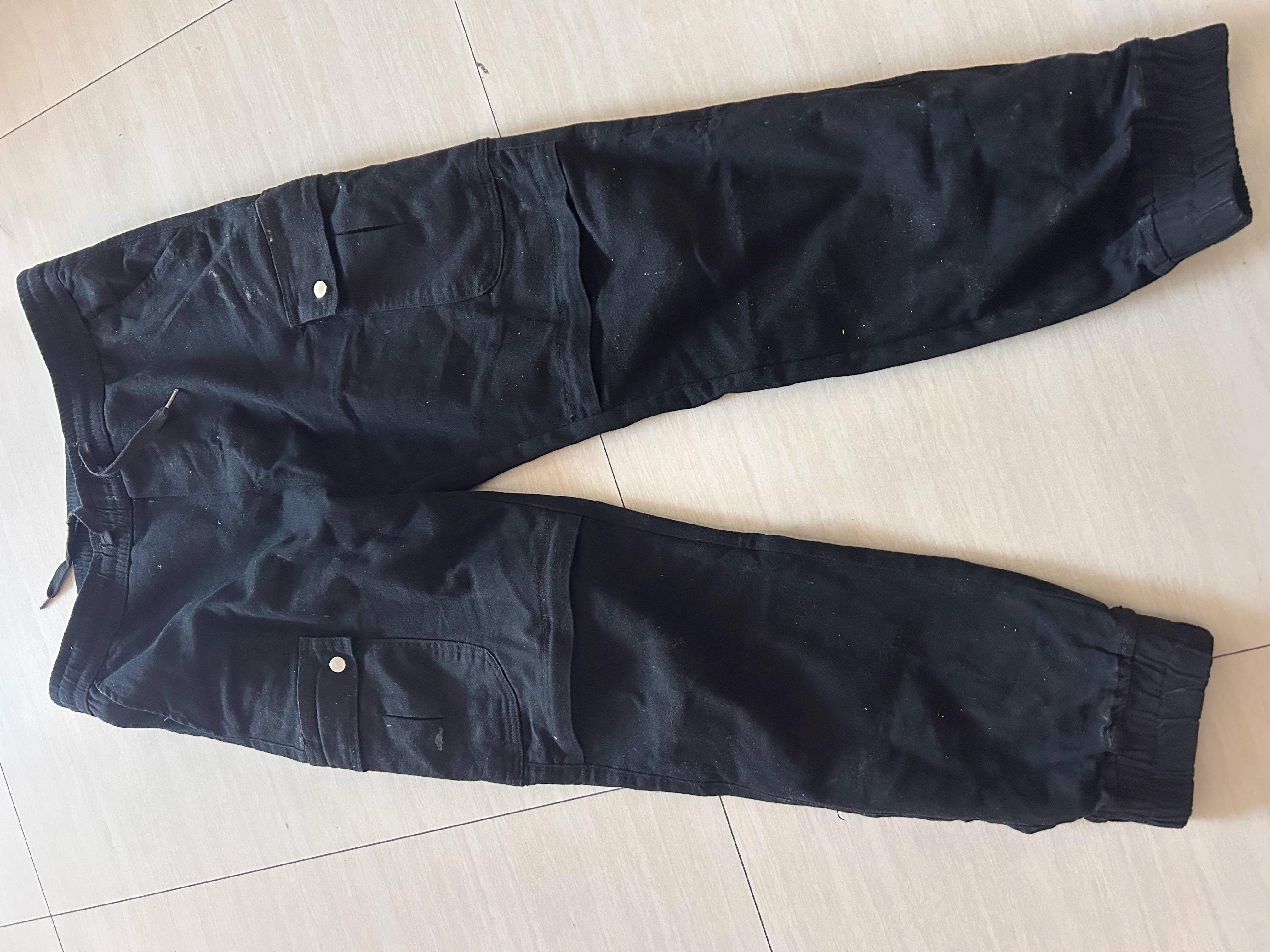 Black pants laid flat on a light-colored floor