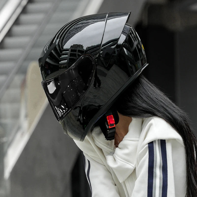 Person wearing a black helmet with reflective visor outdoors