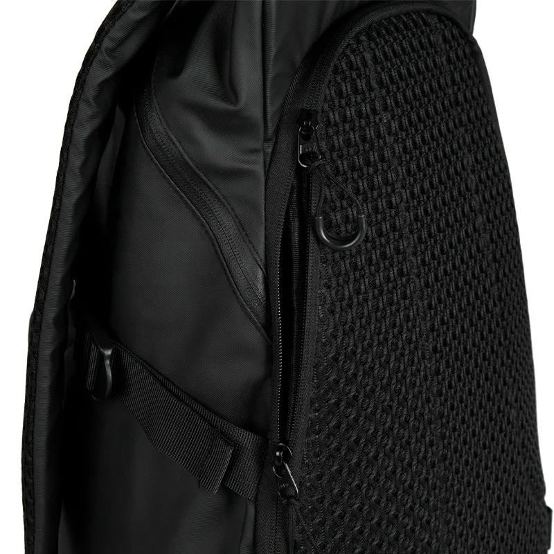 Close-up of a black backpack with a textured back panel on a white background