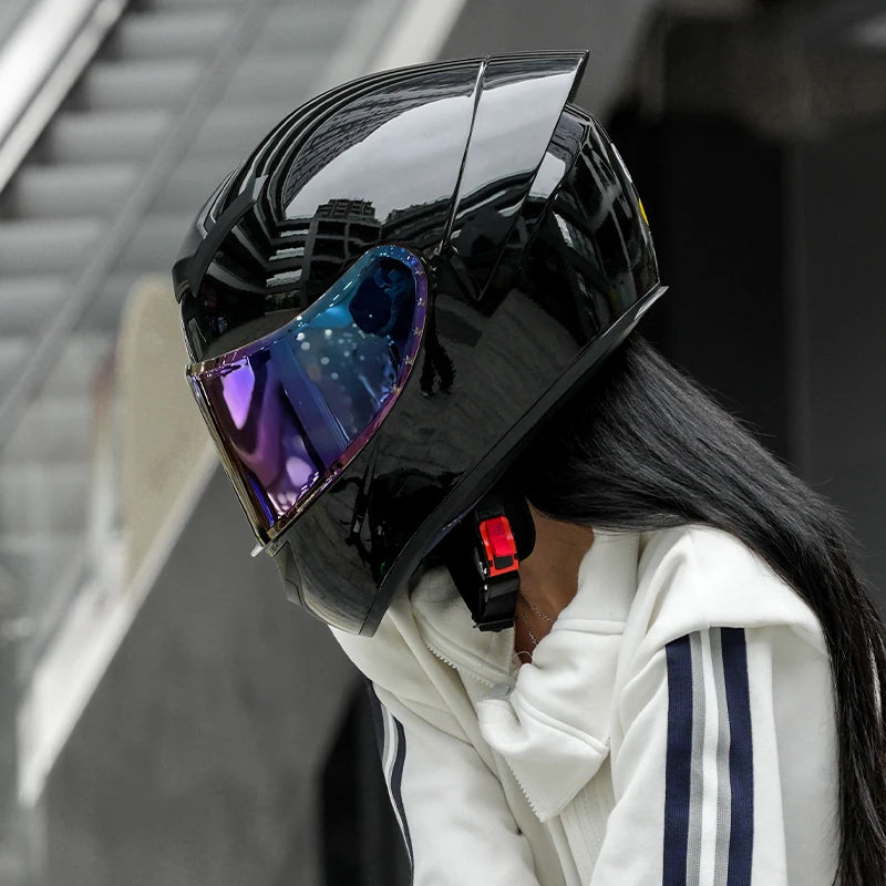 Person wearing a black helmet with reflective visor outdoors